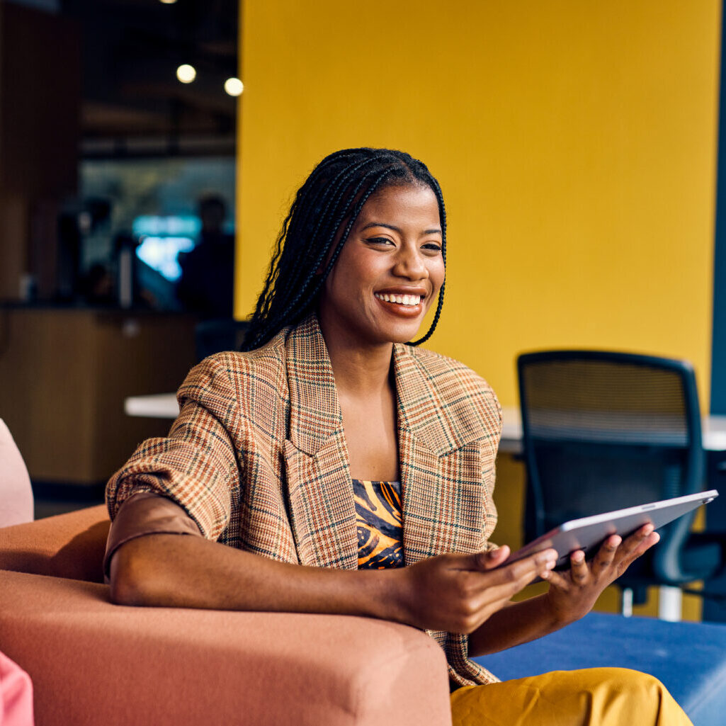 a woman smiling and working on a tablet