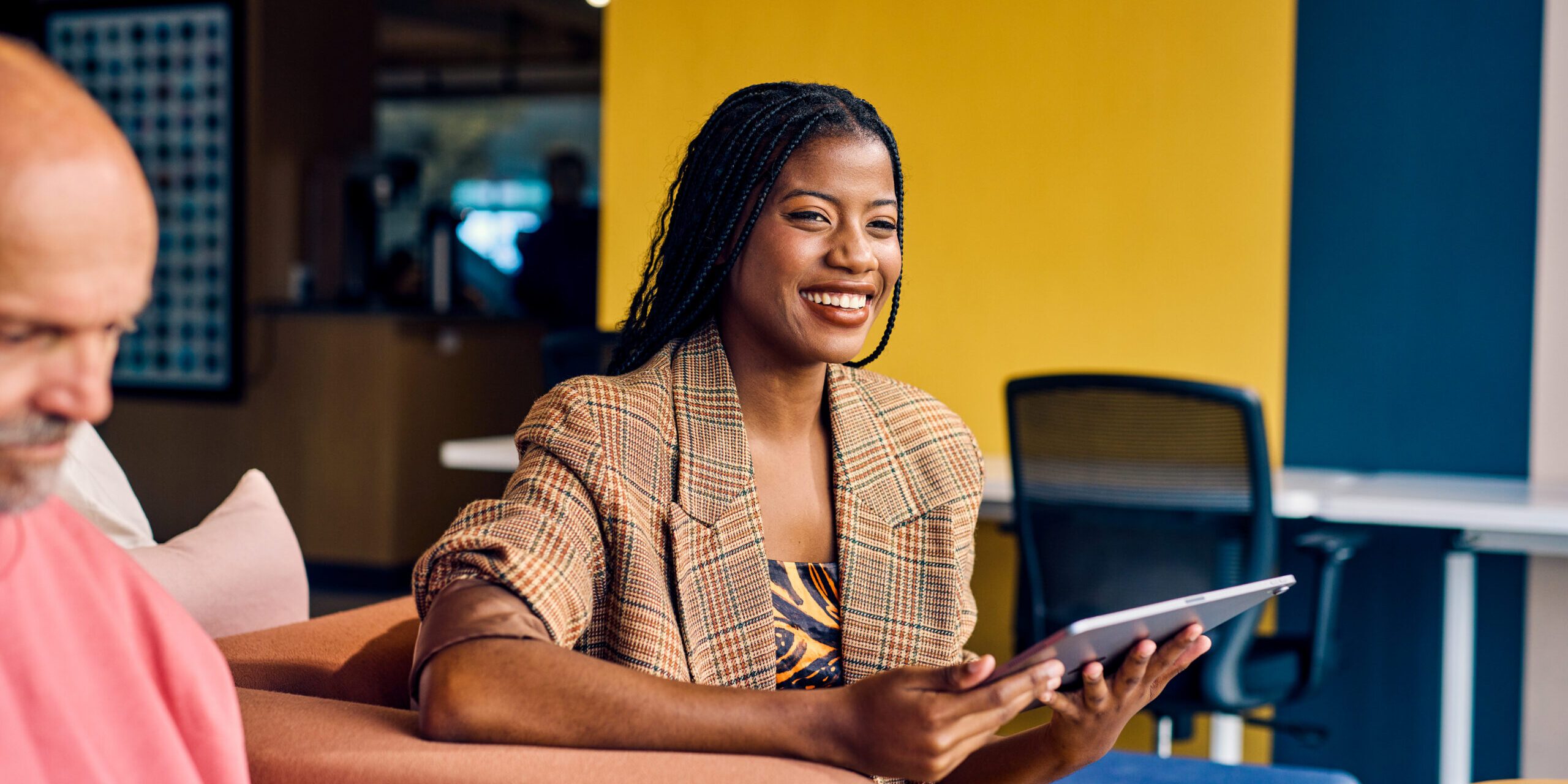 a woman smiling and working on a tablet